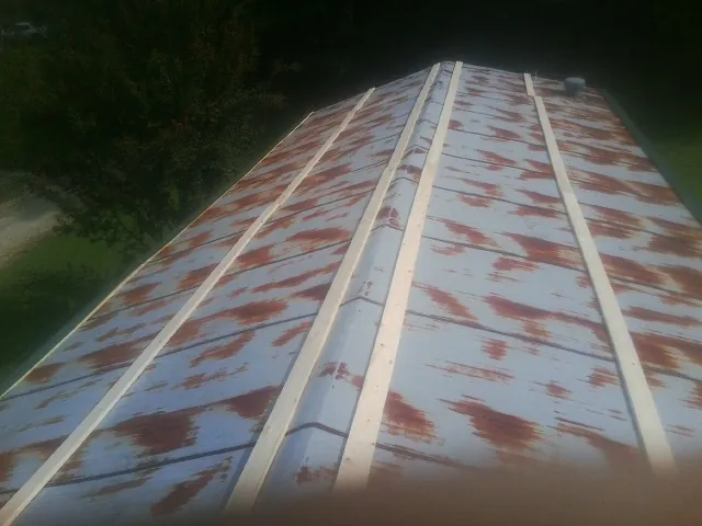 Rusted metal roof panels with new wood purlins before replacement — Storm Damage Roof Repair in Reedley by Roofing Brothers