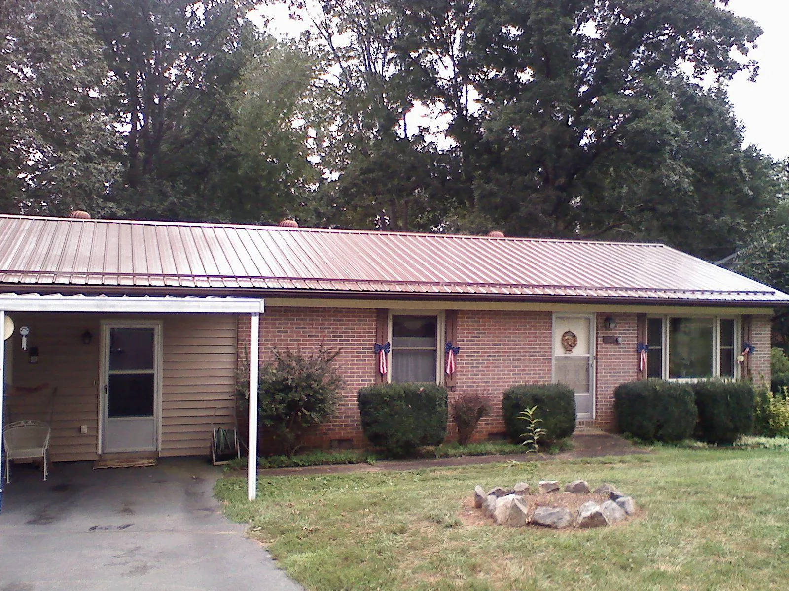 Bronze metal roof and carport on a brick ranch home — Roof Repair work by our crew in Reedley