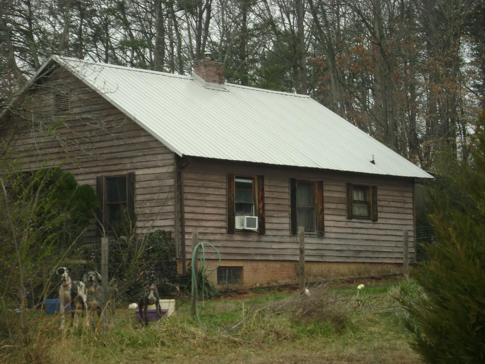 White metal roof on an old wood sided farmhouse, from a Metal Roof Installation job in Reedley